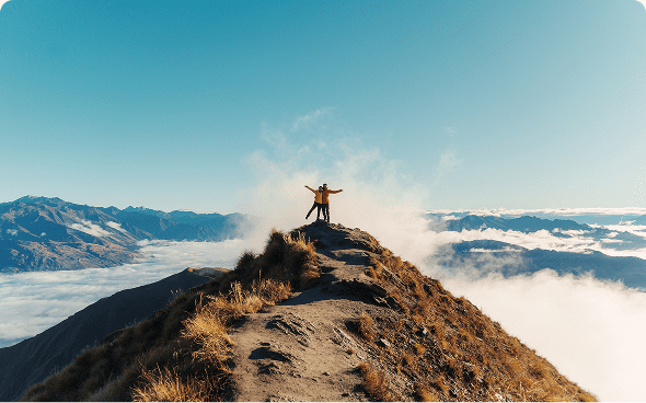 Person celebrating on a mountain ridge