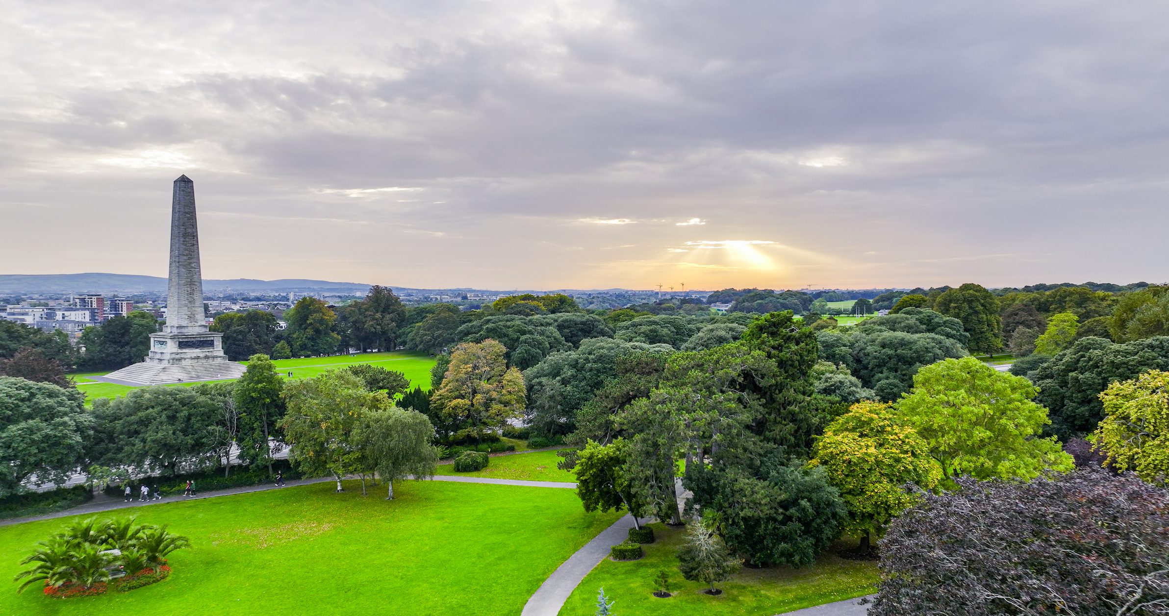 Sunrise over verdant landscape and obelisk