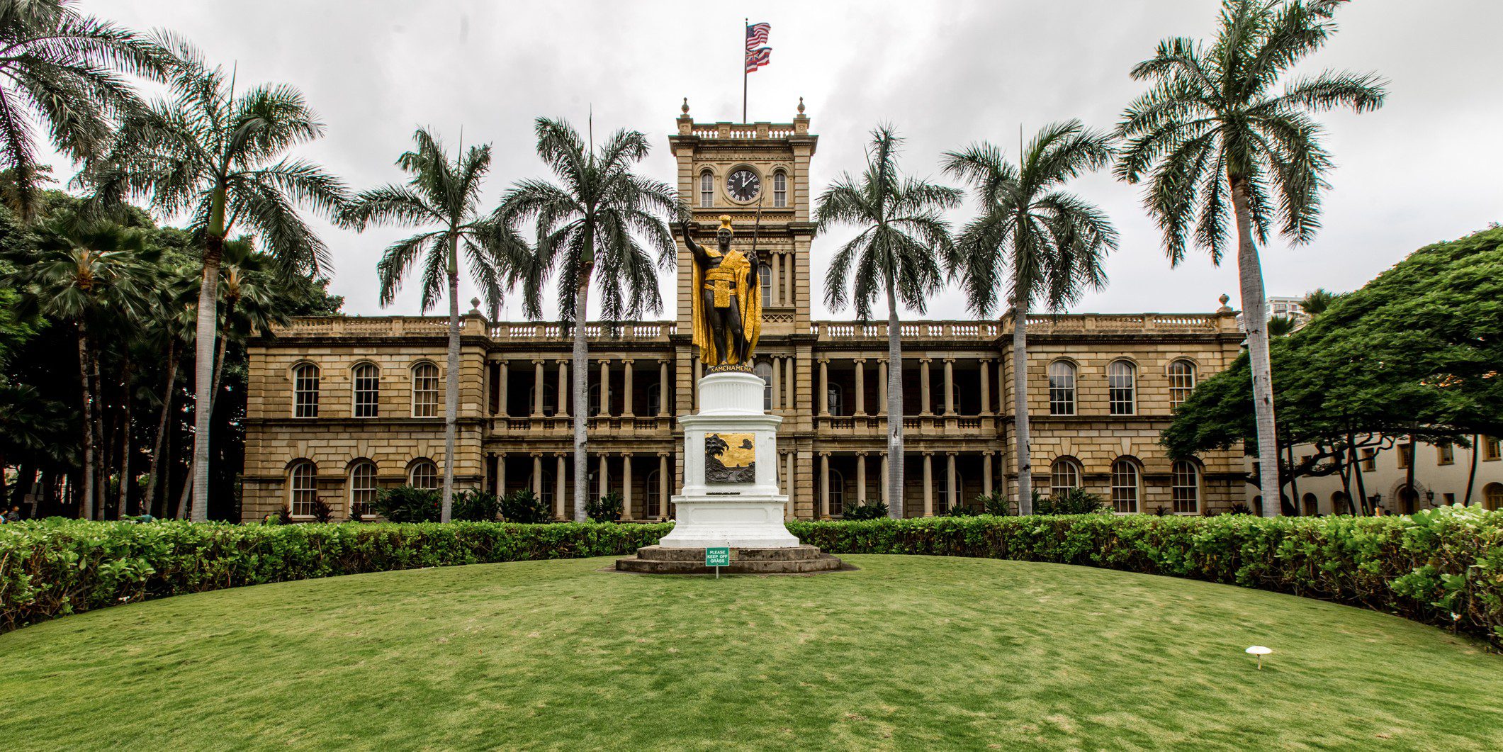 Historic building with statue and palm trees