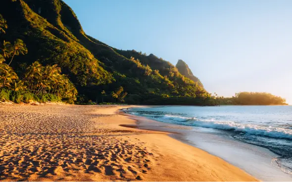 Tropical beach with mountains at sunset.